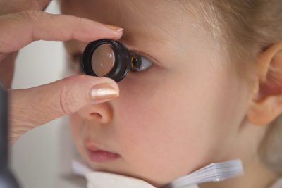 Child in ophthalmology clinic - optometrist diagnosis little blonde girl, close up