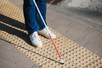 Close-up Of A Blind Man Standing With White Stick On Street.