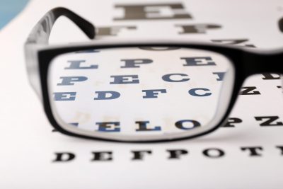 Glasses on eye chart close-up