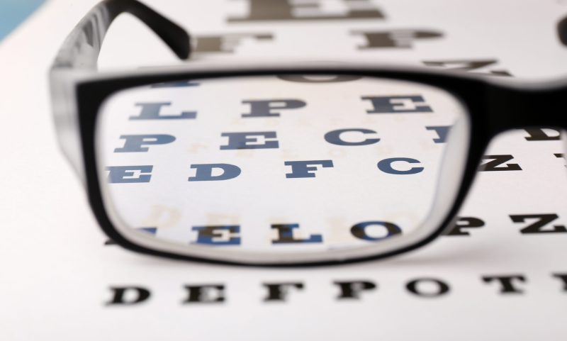 Glasses on eye chart close-up