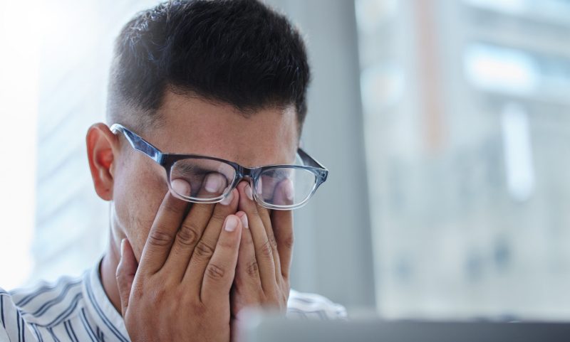 Stress, headache and man with burnout in office for accounting of taxes or finance. Frustrated, person and accountant with brain fog from anxiety, fatigue or working with debt, crisis or mistake.